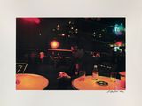 a man that is sitting at a table with a cell phone