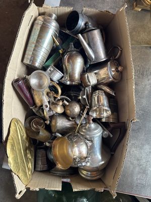 a box full of silver and brass items on the floor