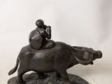 a statue of a man riding a horse on the back of a cow