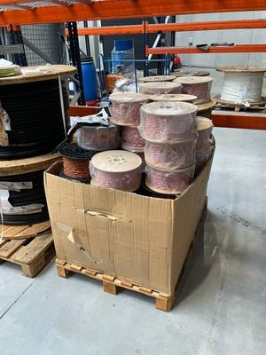 de nombreuses pelotes de laine dans une boîte posée par terre