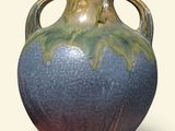 a blue and green vase sitting on a white surface
