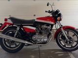 une moto rouge et noire garée devant la porte d'un garage
