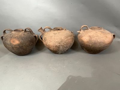 trois vases marron posés les uns à côté des autres sur une table