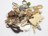a pile of assorted jewelry on a white surface