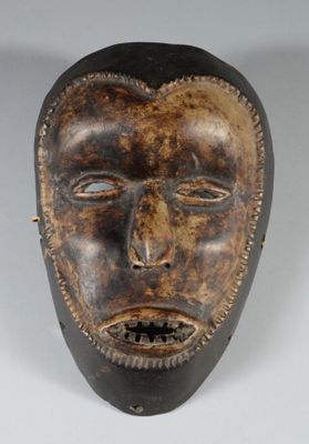 gros plan d'un masque en bois sur une surface blanche