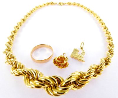 an image of a gold necklace, ring, and bracelet on a white surface