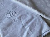 two white towels with monograms are laying on a bed