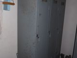 a metal cabinet in a room with a lot of stuff on the floor