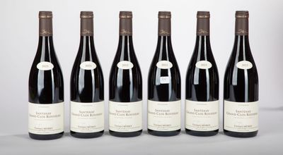 six bottles of wine lined up in a row on a table