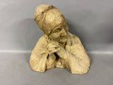 statue d'une femme les mains posées sur son menton