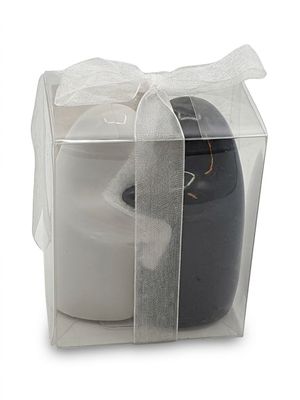 une bougie noire et blanche dans une boîte transparente ornée d'un ruban