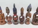 six wooden figurines of different shapes and sizes on a white surface
