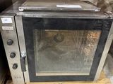a silver microwave sitting on a pallet in a warehouse