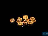 a group of yellow sapphires on a black surface