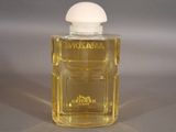 a bottle of perfume sitting on a table on a gray surface