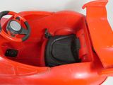 a red toy car with a steering and a steering wheel