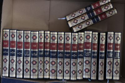 de nombreux livres rangés dans une boîte posée par terre