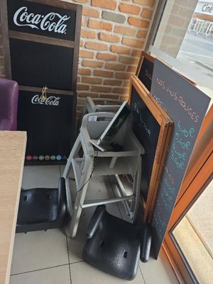 une table avec des chaises et un tableau noir dans un coin de la pièce
