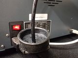 a metal container with a black liquid inside of it