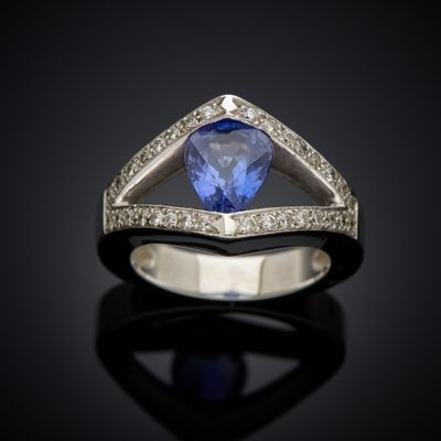 a blue sapphire and diamond ring on a black surface