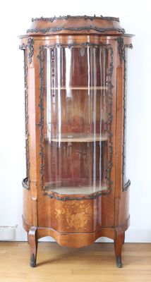 a wooden cabinet with a glass door in the corner