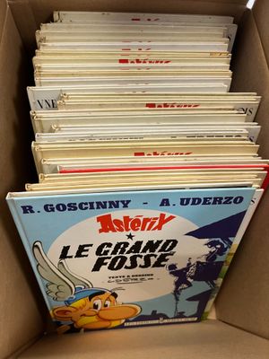 plusieurs livres empilés dans une boîte