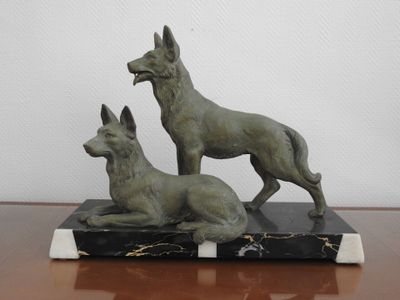 statue représentant deux chiens assis sur un socle en marbre posé sur une table