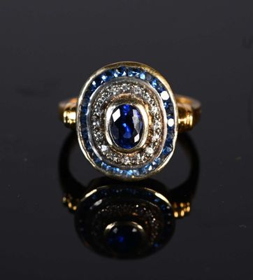a close up of a gold ring with a blue sapphire and diamonds