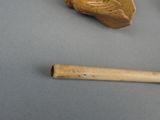 a small piece of wood and a wooden stick on a table