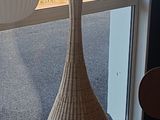 un grand vase posé devant une fenêtre
