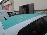 cars parked in front of a building with graffiti on the roof