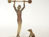 statue of a woman with a barbell and a dog on a white surface