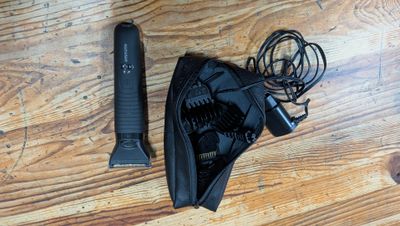 un sèche-cheveux noir et une brosse à cheveux noire posés sur un parquet