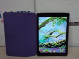 étui violet pour iPad à côté d'une tablette violette posée sur une surface blanche