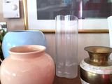 many vases sitting on a table with a picture in the background