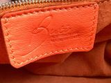 the inside of an orange purse with a zipper on it