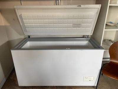 a white chest freezer sitting in the corner of a room