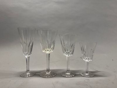 quatre verres à vin sont alignés sur une surface blanche