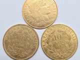 three gold coins, one of which has a crown and one of which has a crown on it