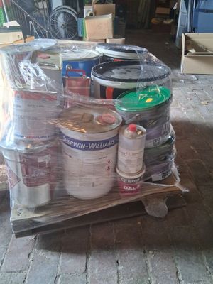 a cart full of cans and cans of paint on the floor