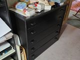a black filing cabinet with a lot of papers on top of it