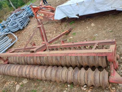 un tracteur couché par terre à côté d'un tas de vieilles machines