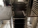 Plusieurs plateaux de nourriture sont posés sur un chariot métallique dans une cuisine