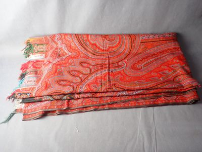 a close up of a red and orange scarf on a white background