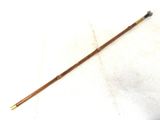 a close up of a stick with a wooden handle on a white surface
