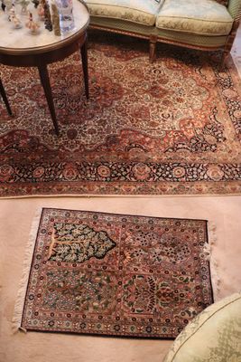 two pictures of a living room with a rug on the floor