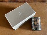 le briquet se trouve à côté de la boîte, sur la surface en cuir