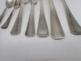 a lot of silver spoons and spoons on the table