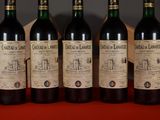 four bottles of wine are lined up on a table