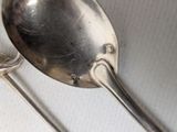 two spoons and a spoon rest on a table